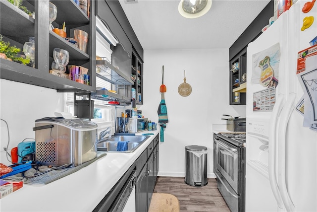 kitchen with hardwood / wood-style flooring, sink, a textured ceiling, and white appliances