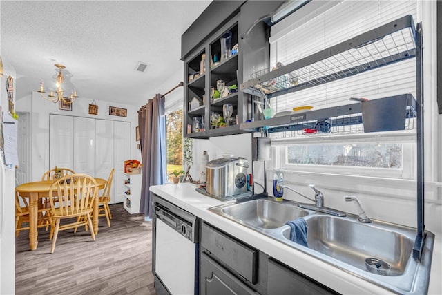 kitchen featuring sink, white dishwasher, hardwood / wood-style floors, and a textured ceiling