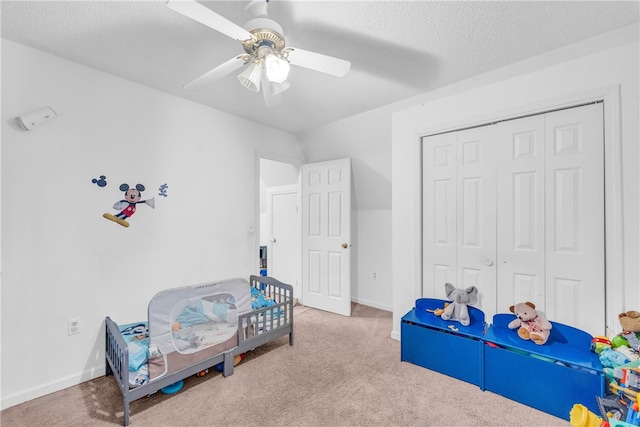 bedroom with carpet, a textured ceiling, ceiling fan, and a closet