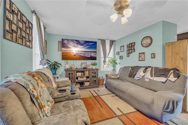 living room with a textured ceiling and ceiling fan