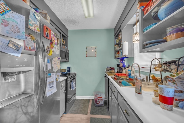 kitchen featuring sink, gray cabinets, stainless steel appliances, and a textured ceiling