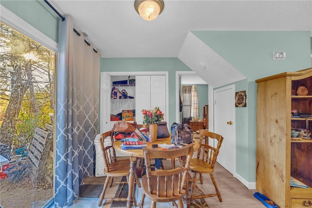 dining room with light hardwood / wood-style flooring and a textured ceiling