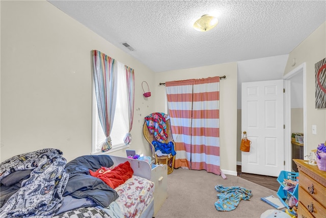 bedroom featuring dark carpet and a textured ceiling