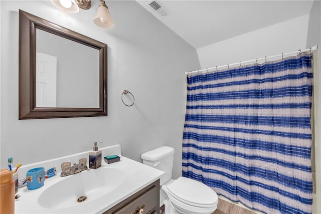 bathroom with a shower with curtain, vanity, toilet, and vaulted ceiling