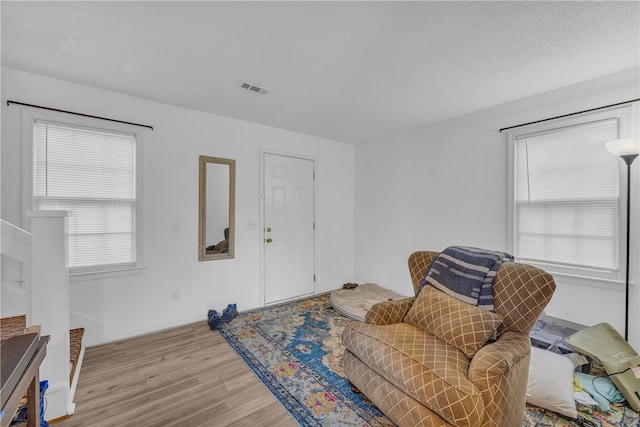 sitting room featuring a textured ceiling and light hardwood / wood-style floors