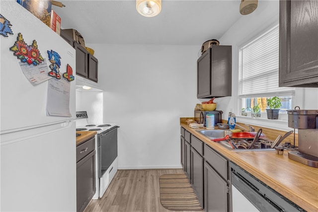 kitchen with white appliances, sink, and light hardwood / wood-style flooring