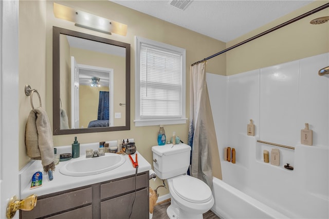 full bathroom with shower / bath combo, vanity, a textured ceiling, and toilet