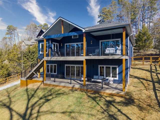 back of property featuring board and batten siding, stairs, a yard, and fence