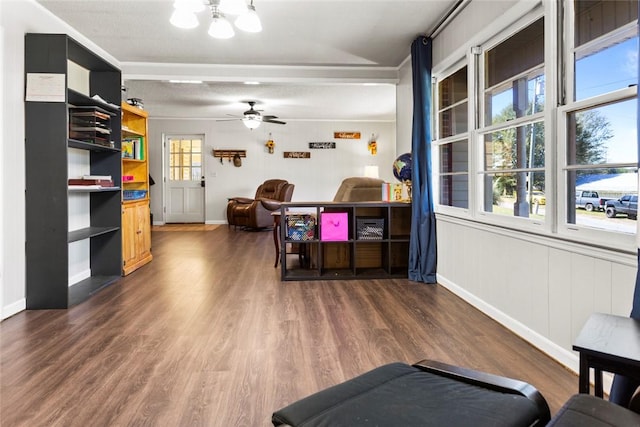 interior space with dark wood-type flooring, ceiling fan, and crown molding