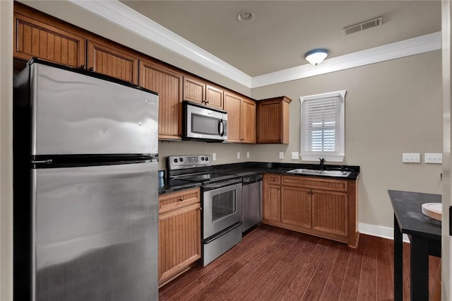 kitchen with stainless steel appliances, crown molding, sink, and dark wood-type flooring