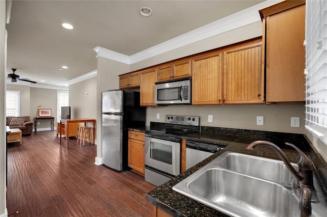 kitchen featuring dark hardwood / wood-style floors, sink, dark stone counters, stainless steel appliances, and crown molding