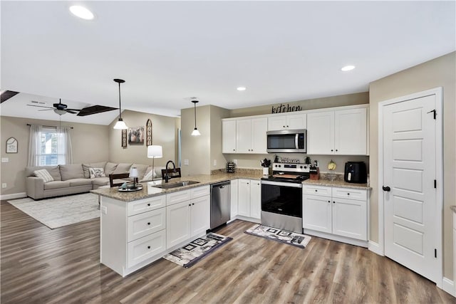 kitchen featuring appliances with stainless steel finishes, sink, white cabinets, and kitchen peninsula