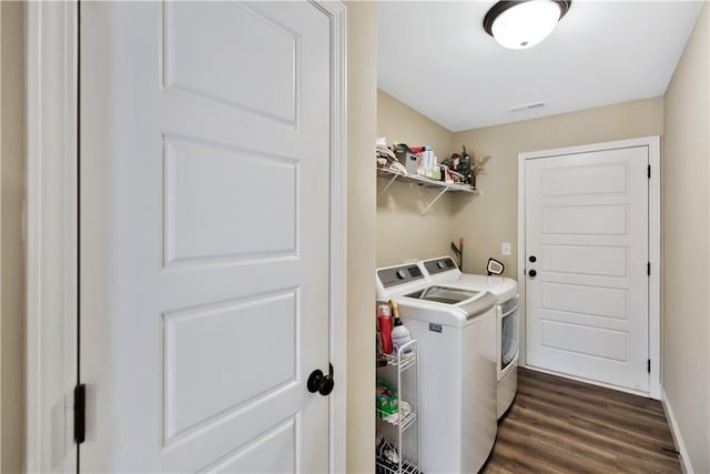 clothes washing area with separate washer and dryer and dark wood-type flooring