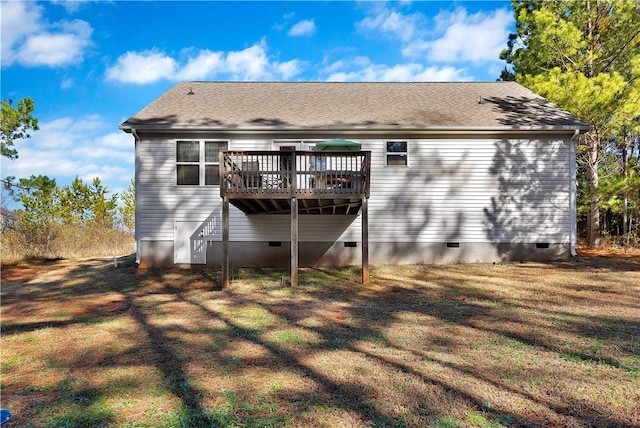 back of property featuring a deck and a lawn