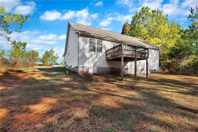 back of property featuring a deck and a lawn