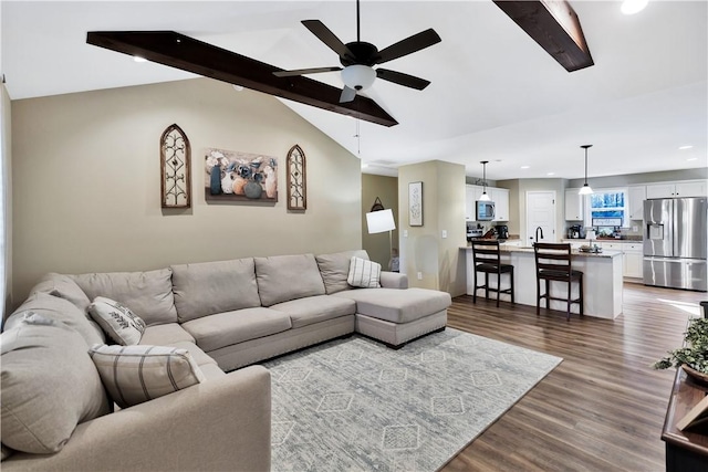 living room featuring lofted ceiling with beams, dark hardwood / wood-style floors, and ceiling fan