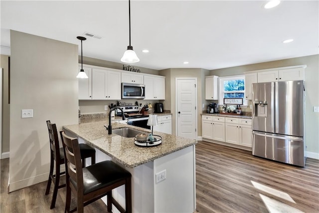 kitchen featuring stainless steel appliances, kitchen peninsula, hanging light fixtures, and white cabinets