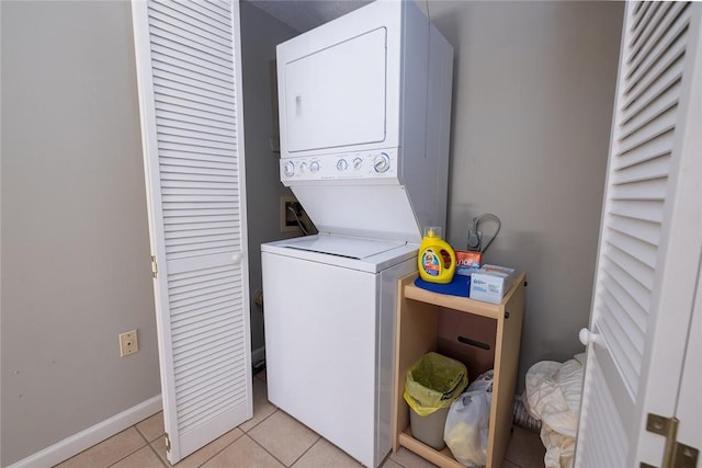 washroom featuring stacked washer and dryer and light tile patterned floors