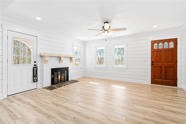 unfurnished living room featuring crown molding, plenty of natural light, and light hardwood / wood-style floors