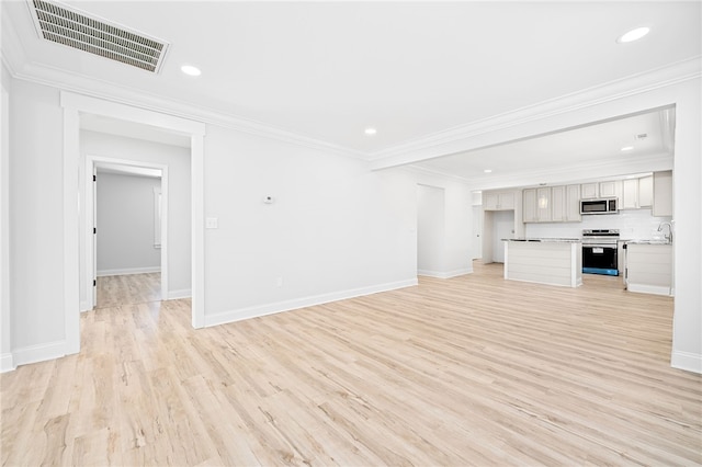 unfurnished living room with sink, light hardwood / wood-style flooring, and ornamental molding