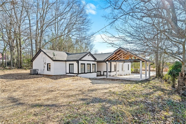 back of property with a patio, a yard, and central air condition unit