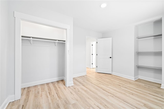 unfurnished bedroom featuring light hardwood / wood-style flooring and a closet