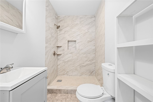 bathroom featuring vanity, toilet, and tiled shower