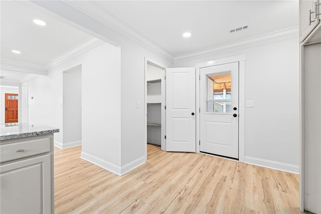 foyer entrance featuring ornamental molding and light hardwood / wood-style floors