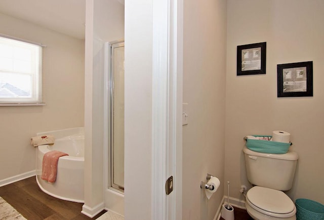 bathroom featuring hardwood / wood-style flooring, toilet, and a shower with door