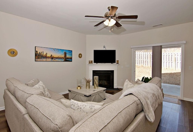 living room featuring ceiling fan and dark hardwood / wood-style flooring