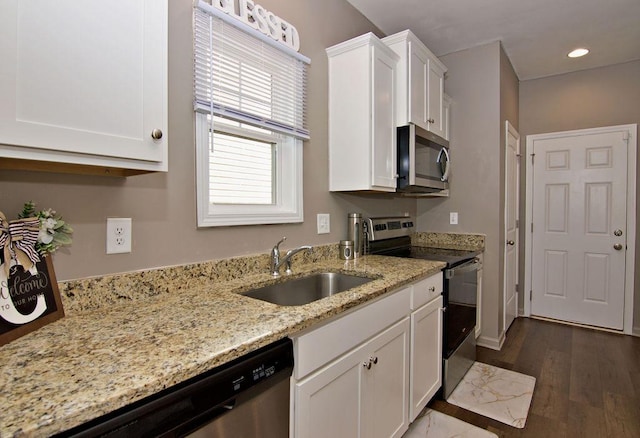 kitchen featuring sink, appliances with stainless steel finishes, dark hardwood / wood-style flooring, light stone countertops, and white cabinets