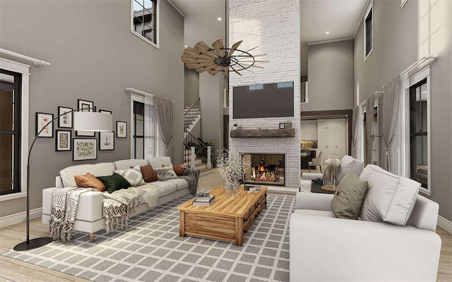 living room featuring wood-type flooring, a towering ceiling, and a fireplace