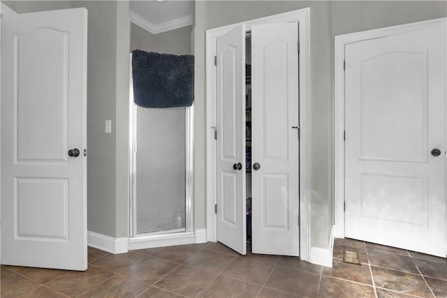 bathroom with an enclosed shower, tile patterned flooring, and ornamental molding