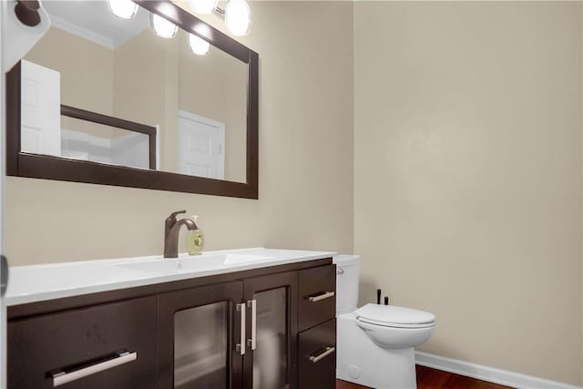 bathroom featuring vanity, crown molding, and toilet