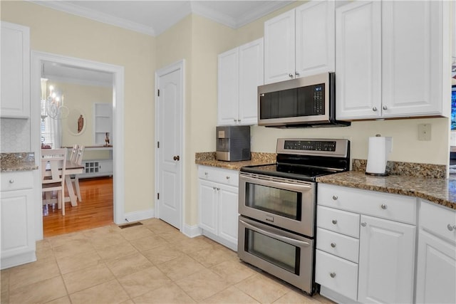 kitchen with white cabinetry, dark stone countertops, and appliances with stainless steel finishes