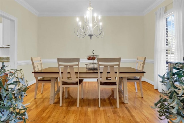 dining space with ornamental molding, an inviting chandelier, and light wood-type flooring