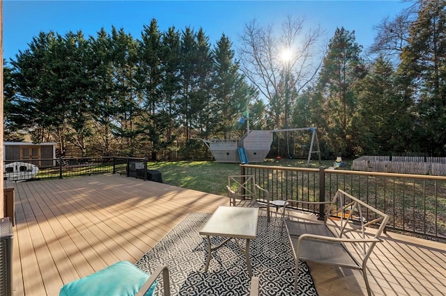 wooden terrace with a storage unit and a lawn