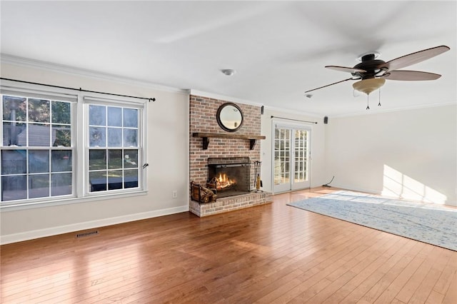 unfurnished living room featuring a brick fireplace, hardwood / wood-style flooring, and ornamental molding