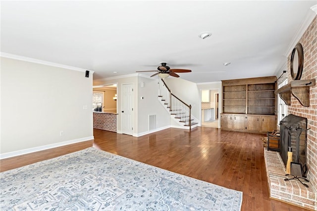 living room featuring a brick fireplace, crown molding, dark hardwood / wood-style floors, and ceiling fan