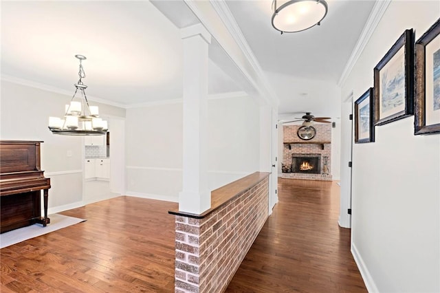 hall with an inviting chandelier, ornamental molding, and hardwood / wood-style floors