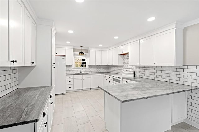 kitchen featuring sink, stone countertops, kitchen peninsula, white appliances, and white cabinets