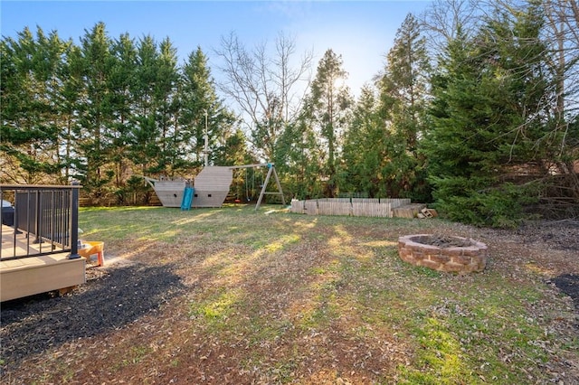 view of yard with a wooden deck and a fire pit