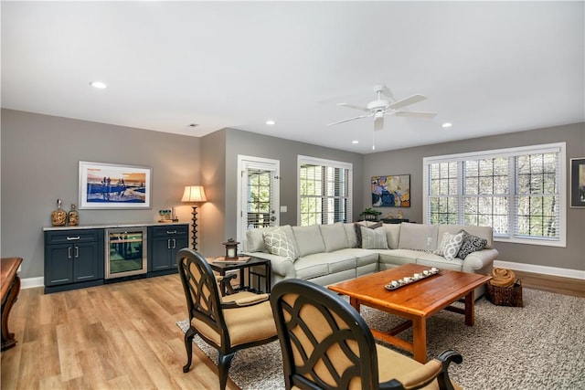 living room with wine cooler, plenty of natural light, and light hardwood / wood-style floors