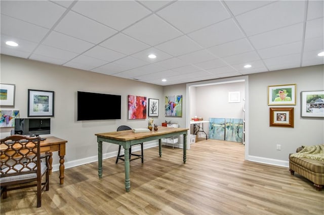 office space with a drop ceiling and light wood-type flooring