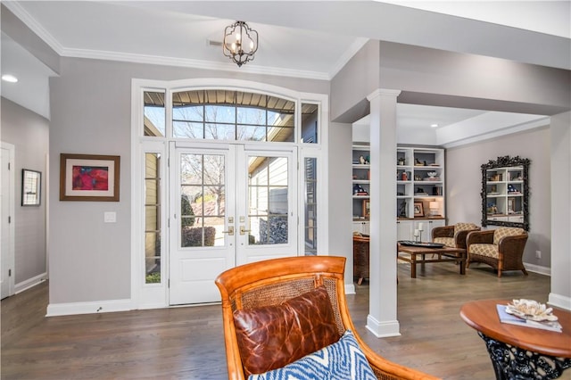 foyer entrance featuring ornate columns, ornamental molding, dark hardwood / wood-style flooring, and french doors