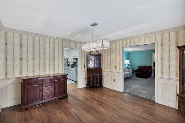 unfurnished dining area with crown molding, dark hardwood / wood-style floors, and a chandelier