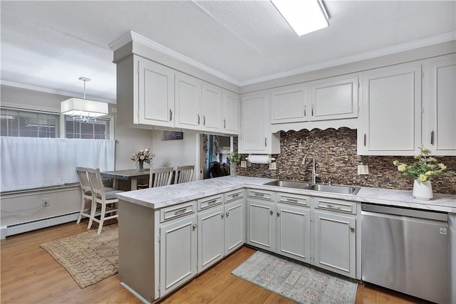 kitchen with sink, light hardwood / wood-style flooring, decorative light fixtures, stainless steel dishwasher, and kitchen peninsula