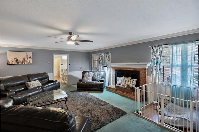 carpeted living room featuring crown molding, ceiling fan, a fireplace, and a textured ceiling