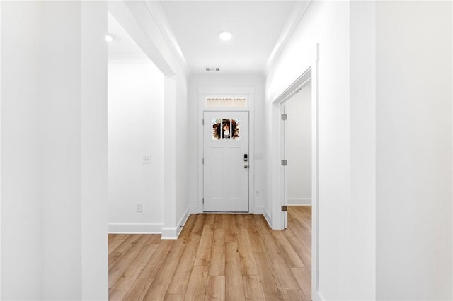 entryway featuring crown molding and light hardwood / wood-style floors