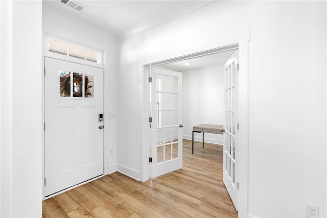 foyer entrance featuring light hardwood / wood-style flooring and french doors